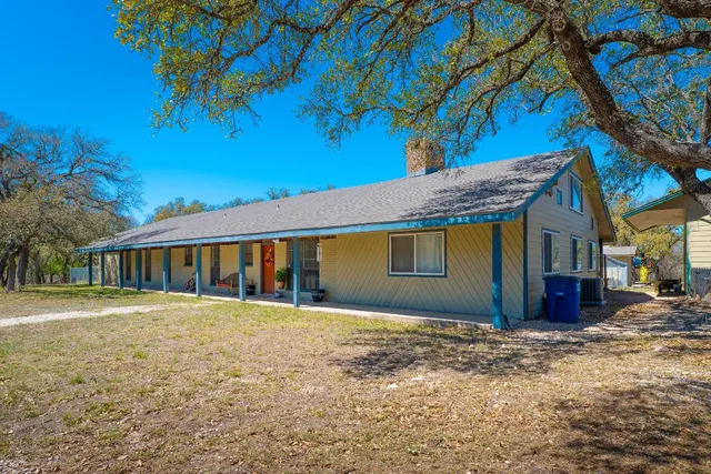 a view of a house with backyard and sitting area