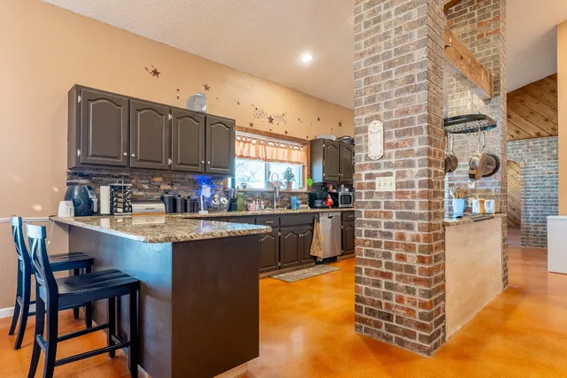 a kitchen with stainless steel appliances granite countertop a stove sink and cabinets