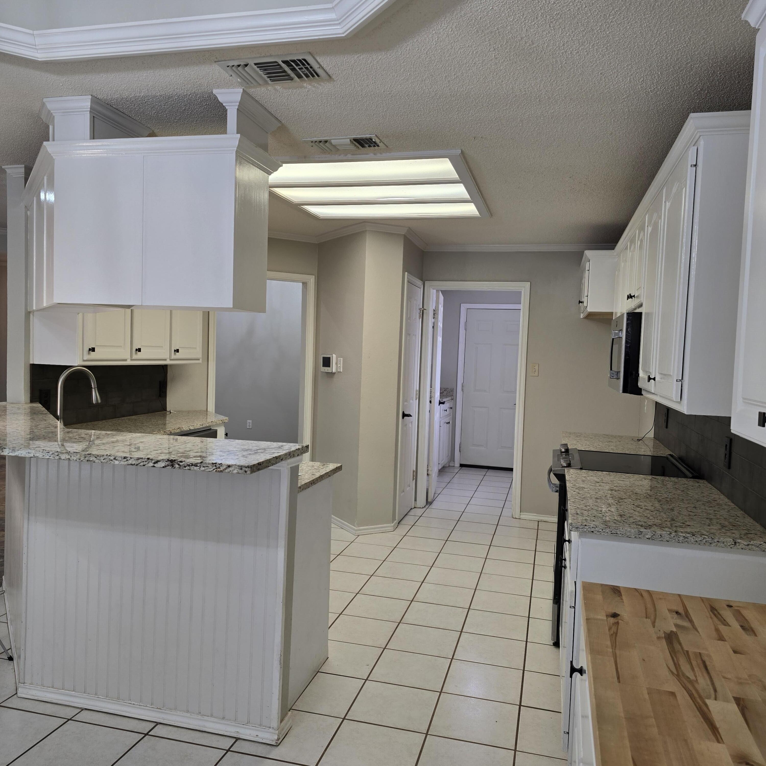 6701 Chicago Avenue Lubbock, TX 79424 - Photo 9 of 35 a kitchen with stainless steel appliances granite countertop a sink and a stove