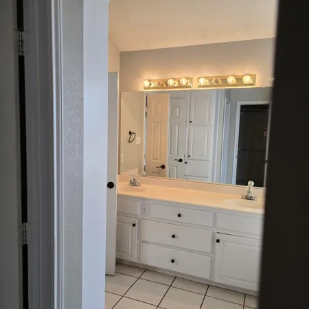 a view of a room with wooden floor closet fan and windows