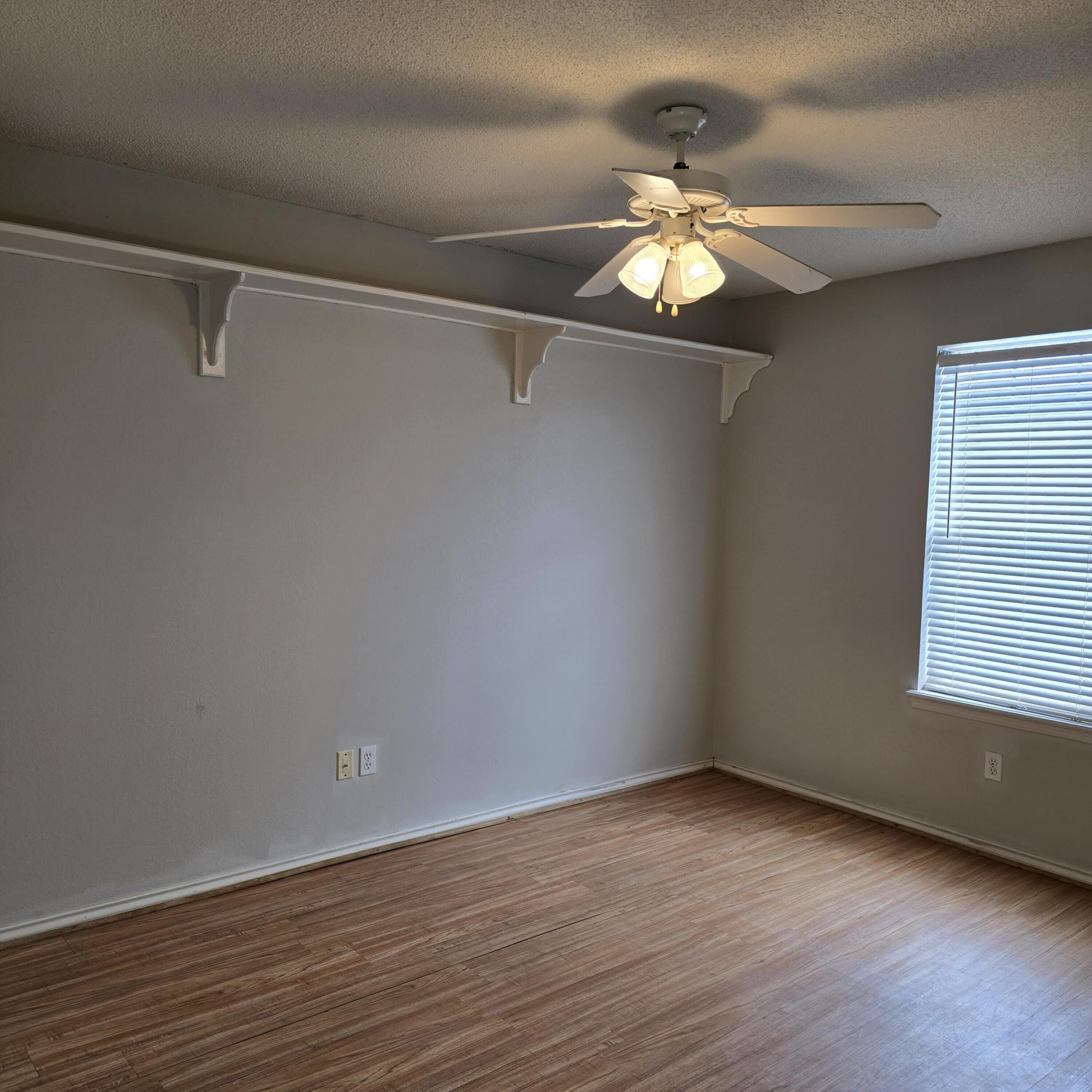6701 Chicago Avenue Lubbock, TX 79424 - Photo 21 of 35 a view of a room with wooden floor closet fan and windows
