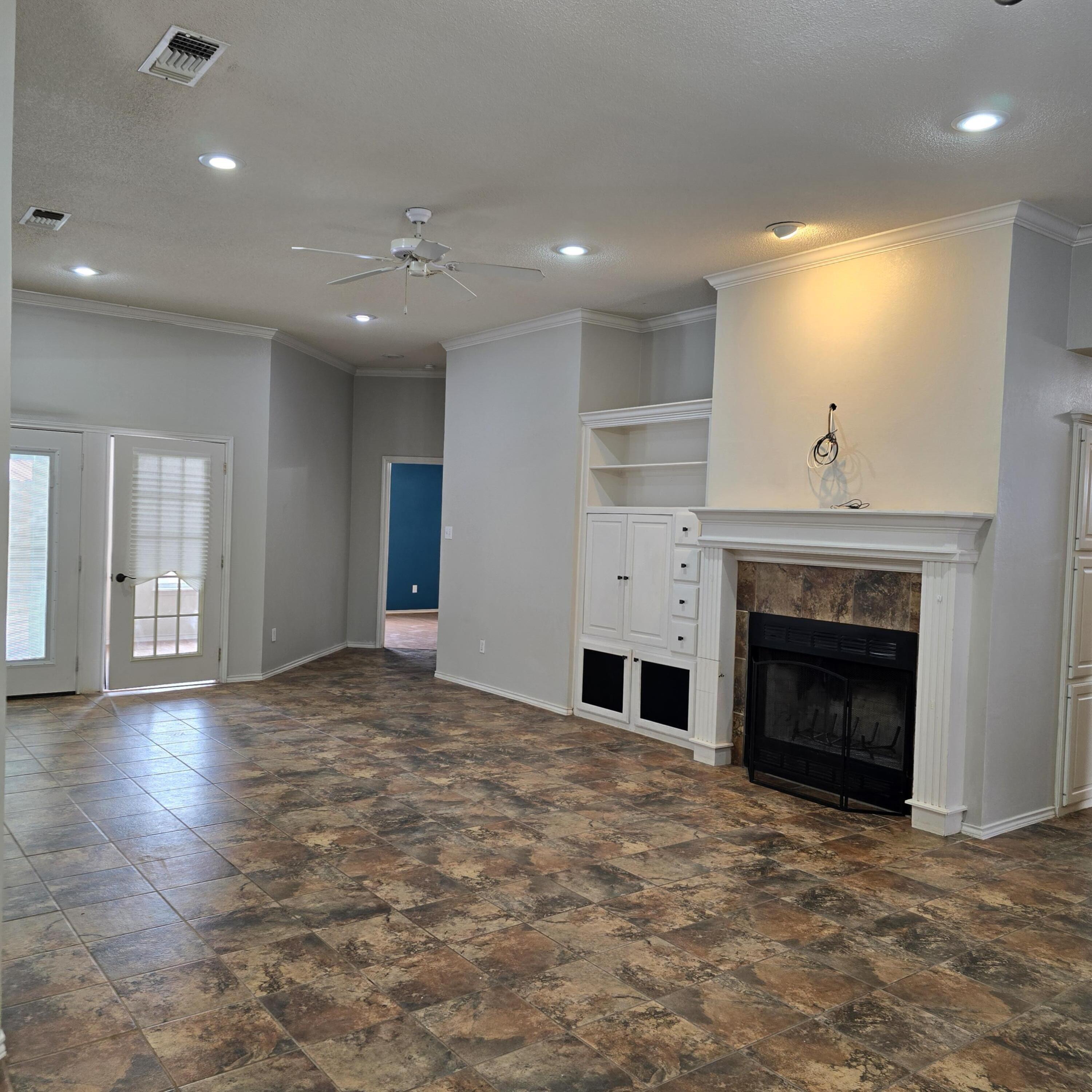 6701 Chicago Avenue Lubbock, TX 79424 - Photo 5 of 35 a view of an empty room with a fireplace and a window
