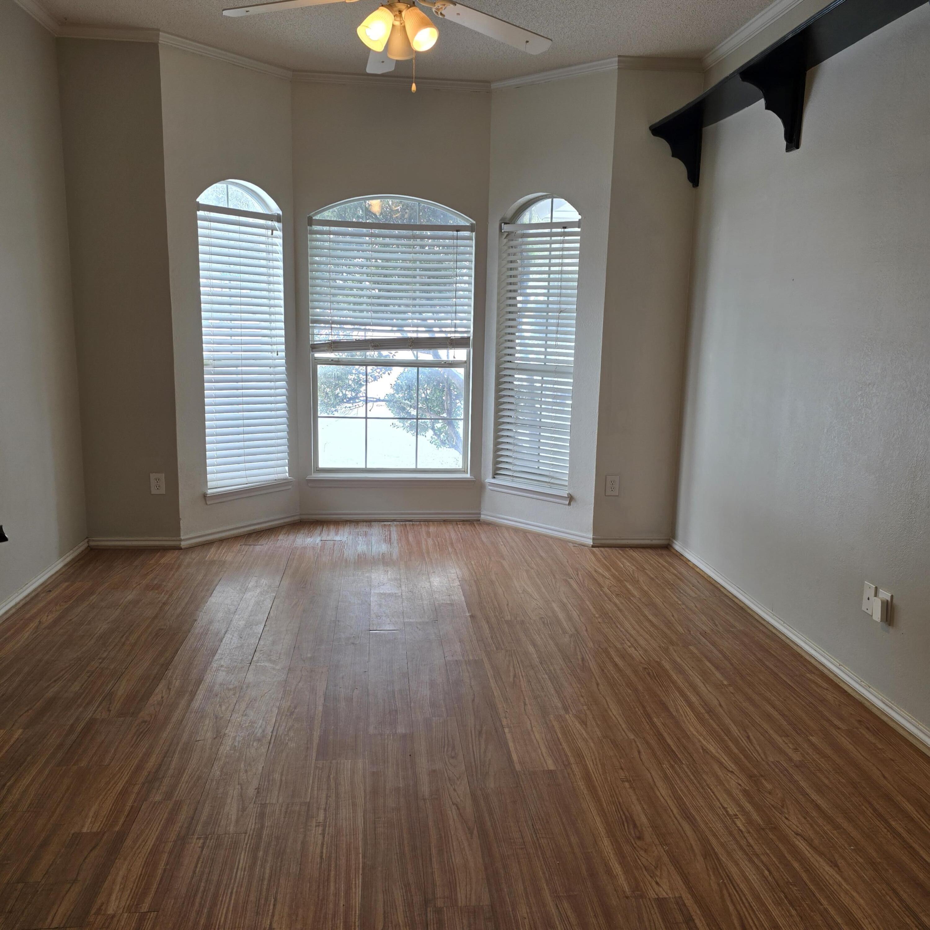 6701 Chicago Avenue Lubbock, TX 79424 - Photo 6 of 35 an empty room with wooden floor and windows