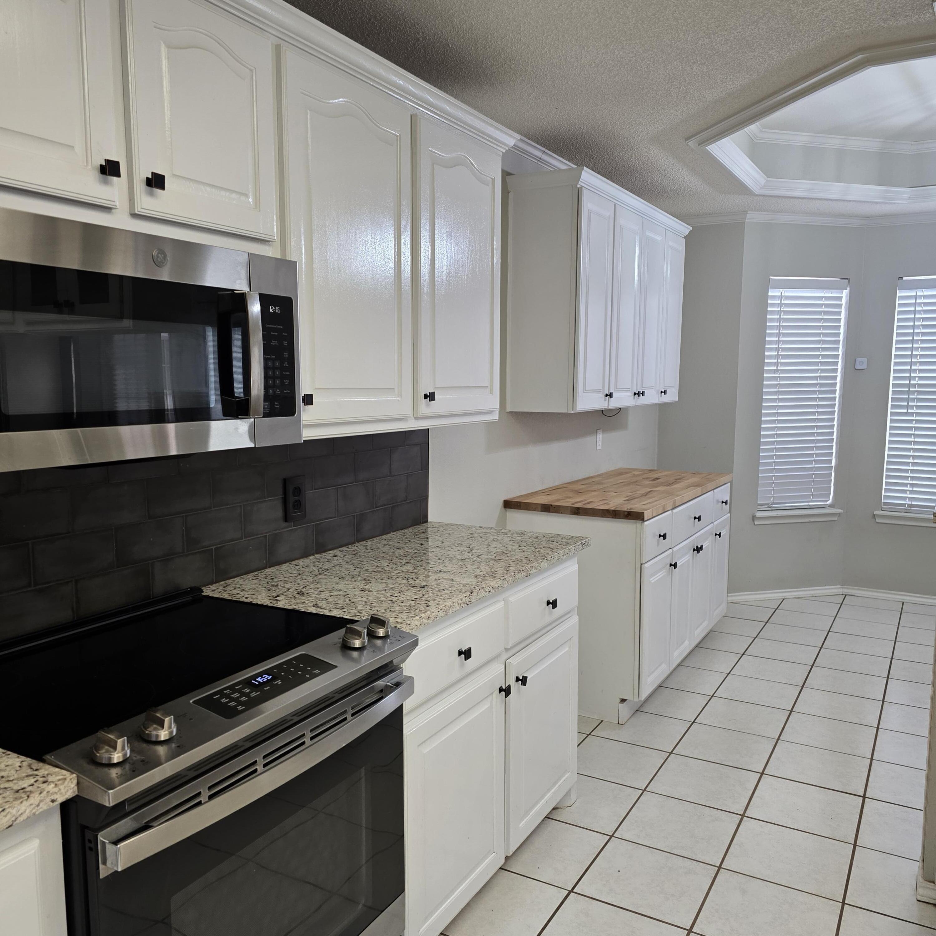 6701 Chicago Avenue Lubbock, TX 79424 - Photo 7 of 35 a kitchen with granite countertop a stove and a sink