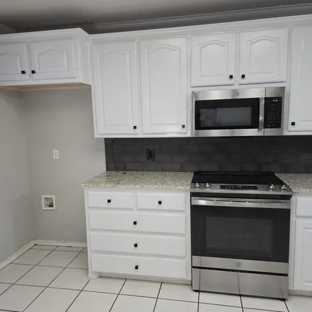 a kitchen with granite countertop a stove and a sink