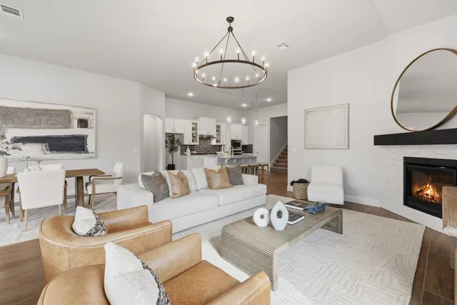 a living room with furniture a fireplace and a chandelier