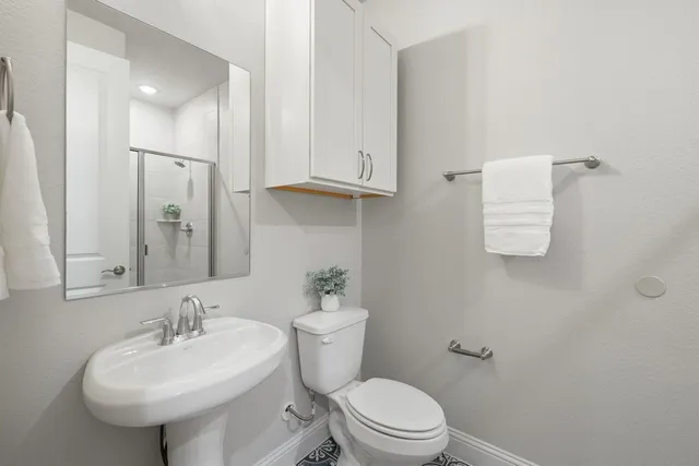 a bathroom with a sink toilet and mirror