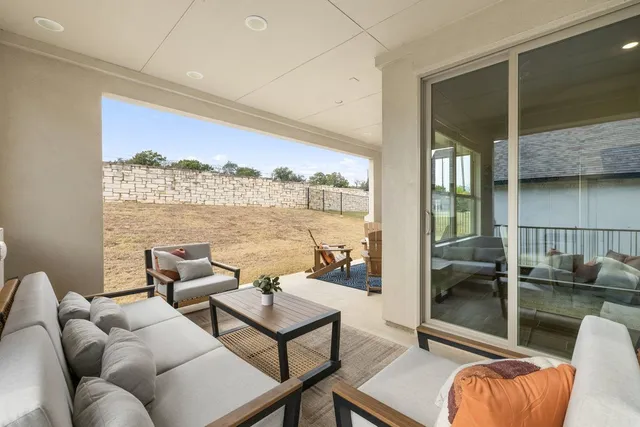 a balcony with furniture and a floor to ceiling window