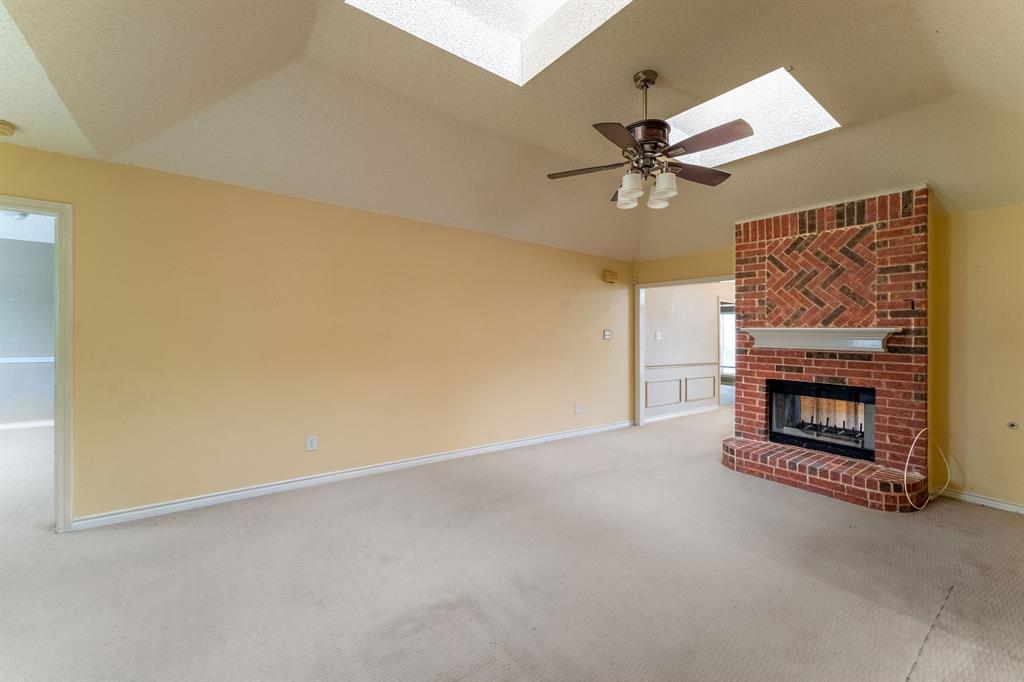 an empty room with a fireplace and fan