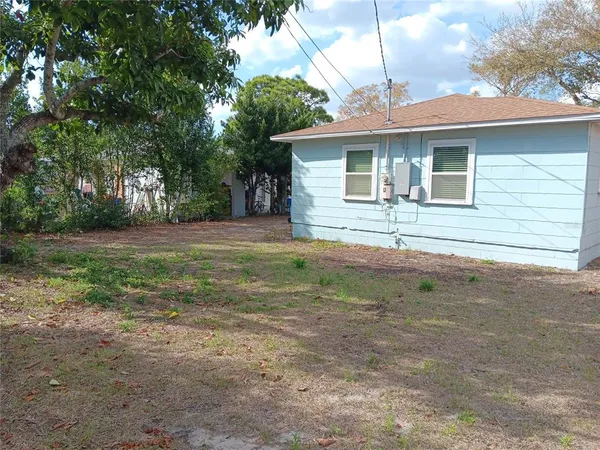 a front view of house with yard and trees around