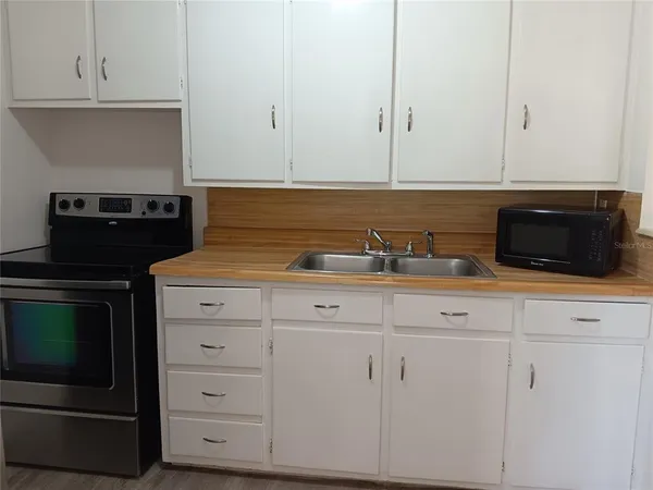 a kitchen with white cabinets and sink