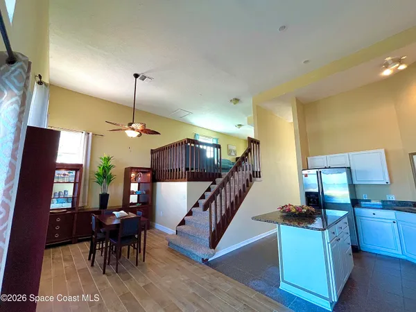 a view of a dining room with furniture a chandelier and wooden floor