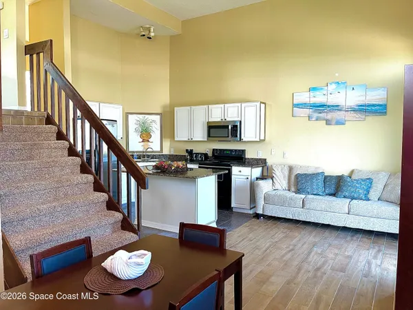 a living room with furniture and a dining table with kitchen view