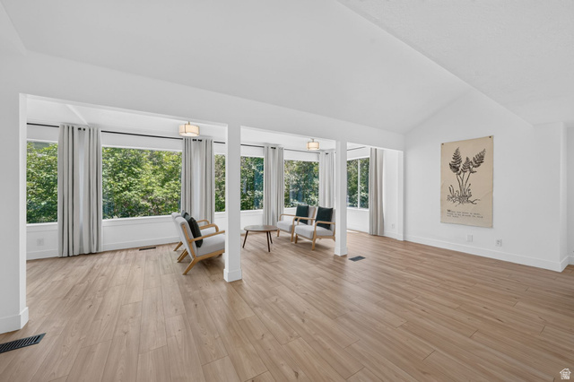 1979 Cave Hollow Way Bountiful, UT 84010 - Photo 16 of 59 Expansive room featuring wood-finish flooring, vaulted ceilings, and a wall of windows