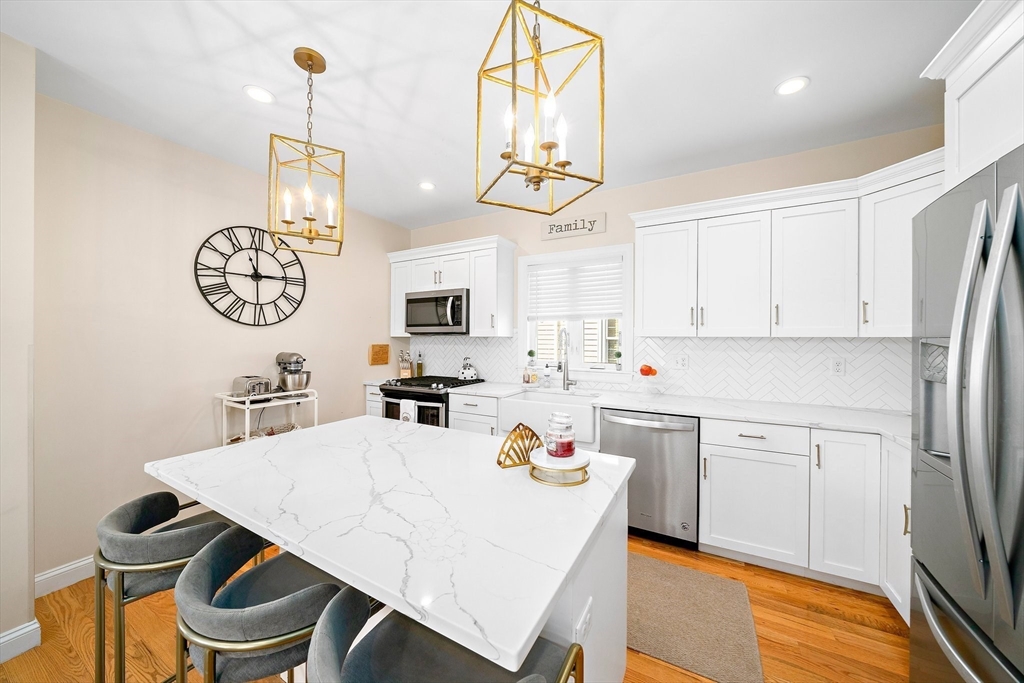 11 Mason Street, Unit 2 Everett, MA 02149 - Photo 12 of 28 a kitchen with white cabinets stainless steel appliances and dining table