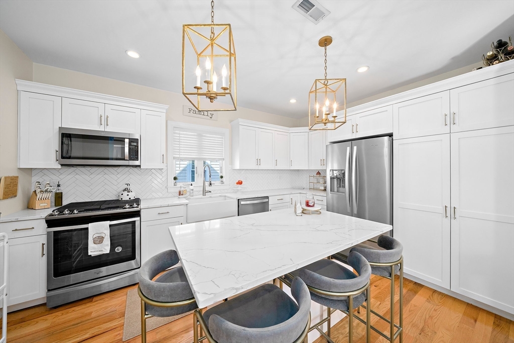 11 Mason Street, Unit 2 Everett, MA 02149 - Photo 10 of 28 a kitchen with stainless steel appliances a dining table chairs microwave and sink