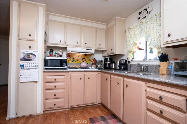a kitchen with granite countertop white cabinets and stainless steel appliances