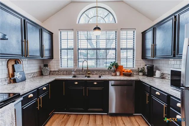 a kitchen with a sink stove top oven and cabinets