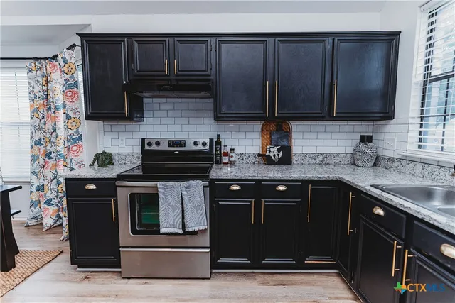 a kitchen with stainless steel appliances granite countertop a stove a sink dishwasher and a microwave