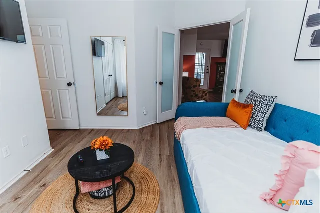 a bedroom with a bed and wooden floor