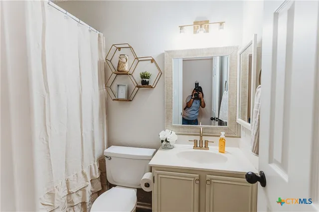 a bathroom with a sink mirror vanity and toilet