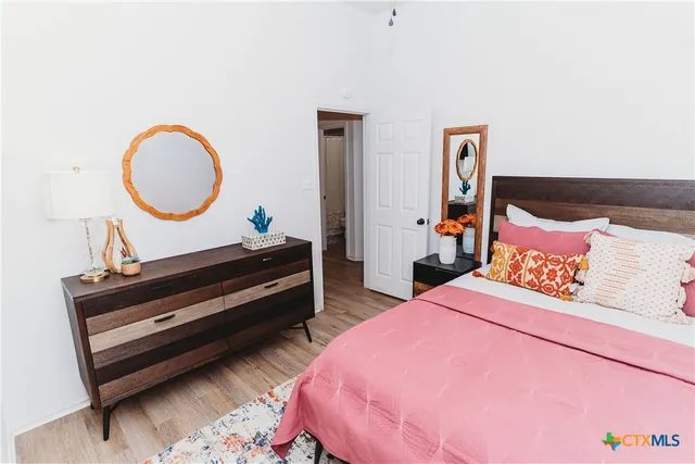 a bedroom with bed and a potted plant