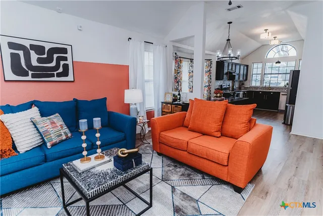 a living room with furniture a rug and kitchen view