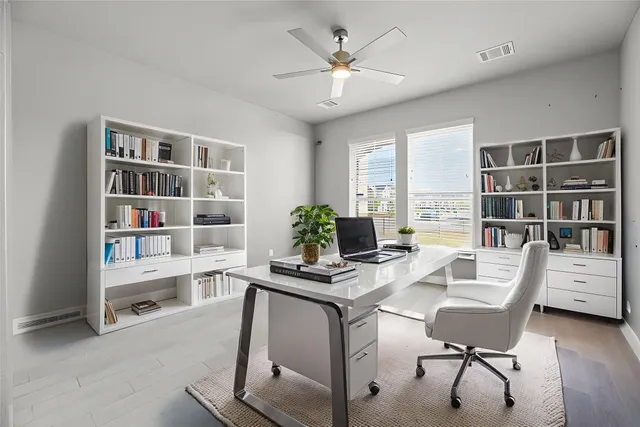 a view of a workspace with furniture and a window