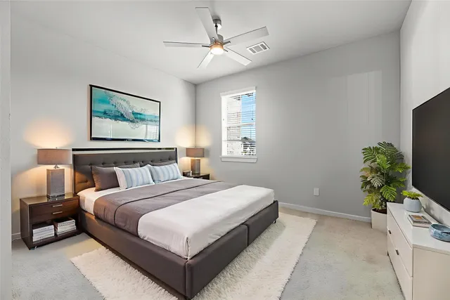 a spacious bedroom with a bed and a potted plant