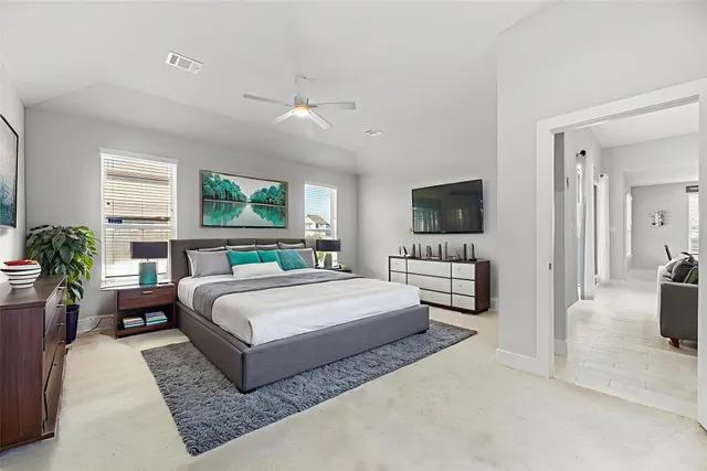 a spacious bedroom with a large bed a flat screen tv and a couch