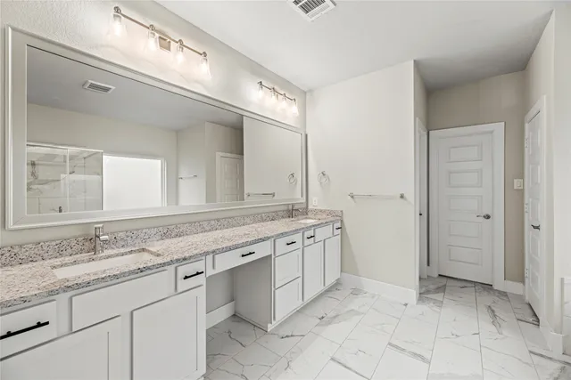 a spacious bathroom with a granite countertop sink a mirror and a