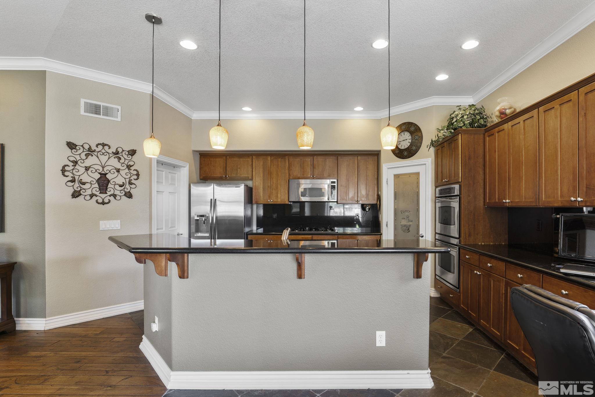10080 Goler Wash Court Reno, NV 89521 - Photo 11 of 40 a kitchen with stainless steel appliances granite countertop a sink a stove and a refrigerator