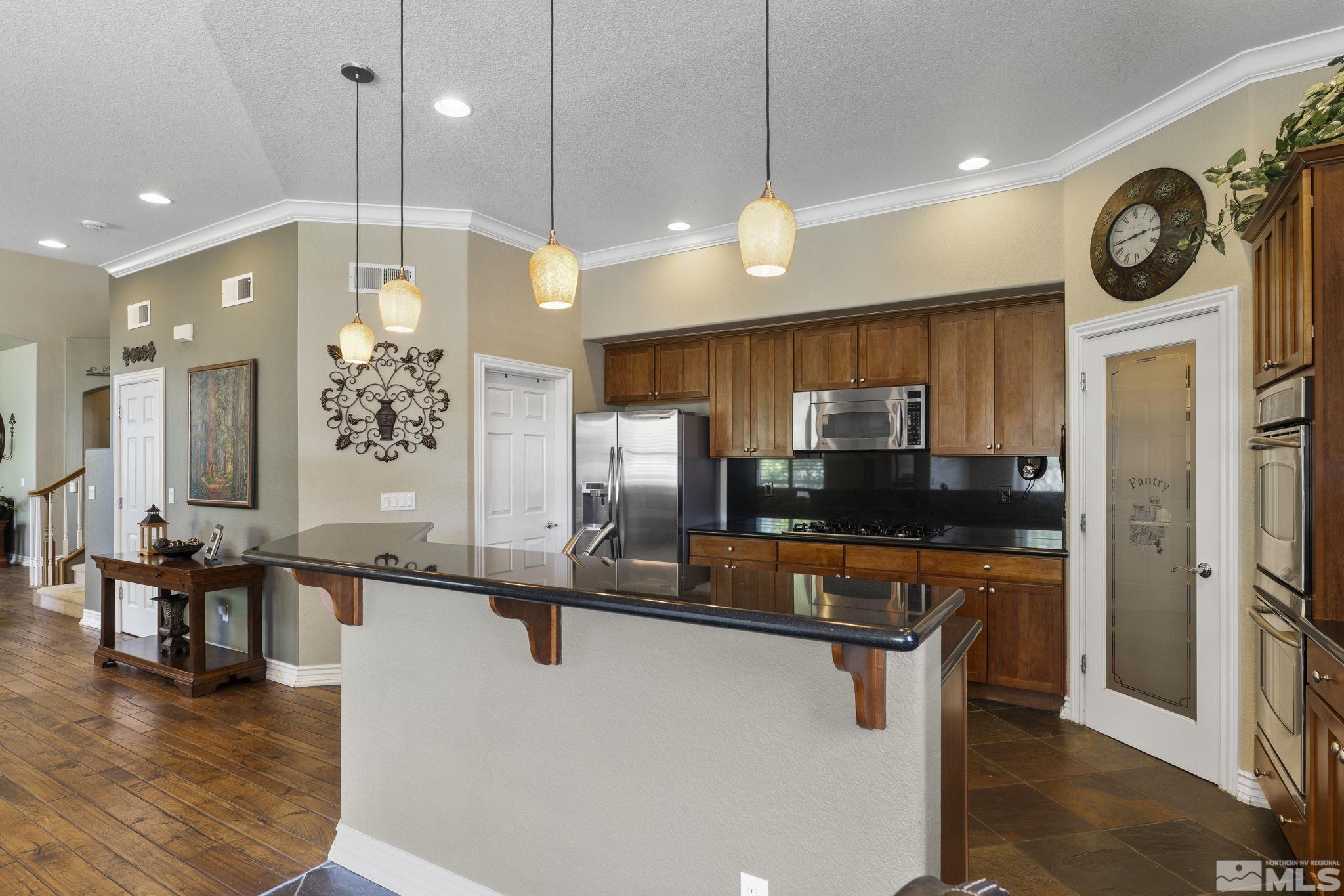 10080 Goler Wash Court Reno, NV 89521 - Photo 12 of 40 a kitchen with stainless steel appliances granite countertop a refrigerator a stove and a wooden floors