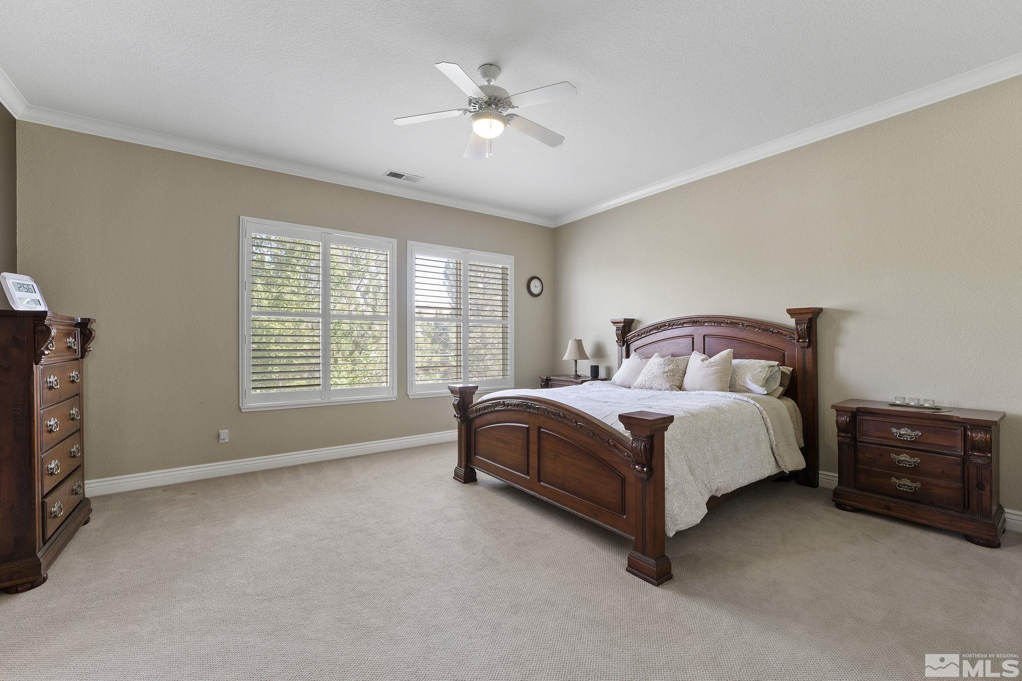 10080 Goler Wash Court Reno, NV 89521 - Photo 18 of 40 a spacious bedroom with a bed and a ceiling fan