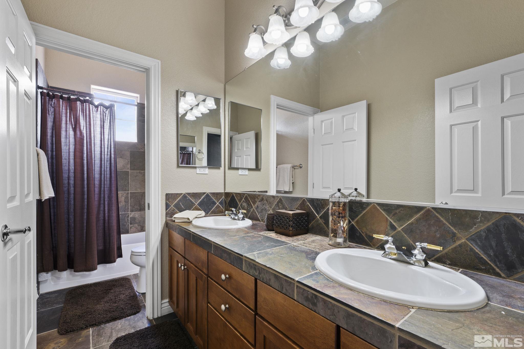 10080 Goler Wash Court Reno, NV 89521 - Photo 27 of 40 a bathroom with a granite countertop sink and a mirror
