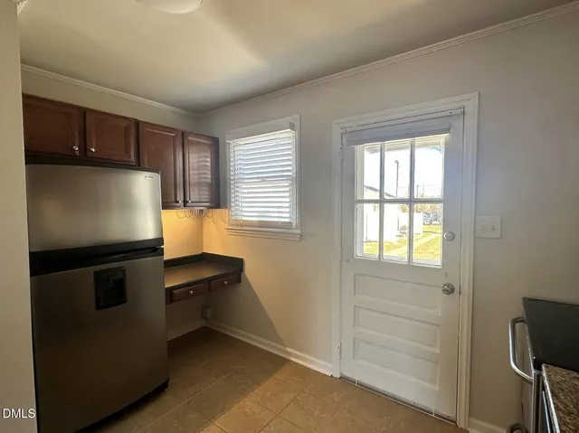 a kitchen with a refrigerator and a stove top oven