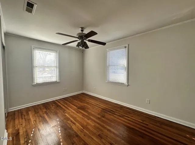 a view of an empty room with a window and a ceiling fan