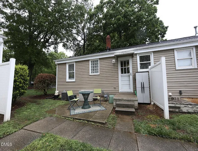 a backyard of a house with yard and outdoor seating