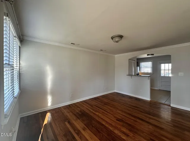 a view of empty room with wooden floor