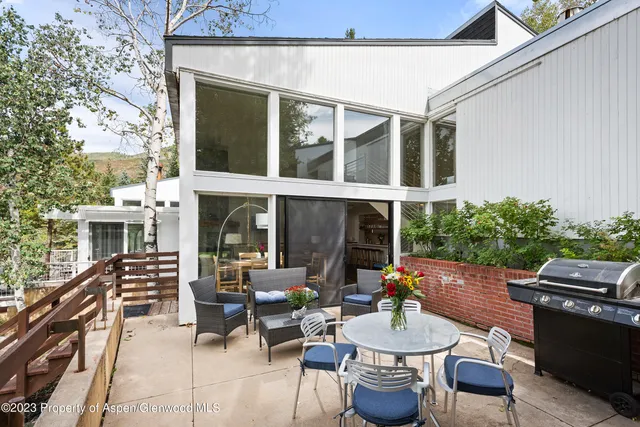 a patio with couches table and chairs and potted plants
