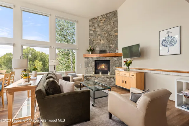 a living room with furniture a large window and a fireplace