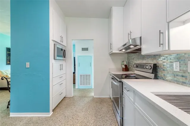a kitchen with stainless steel appliances granite countertop a stove and a refrigerator