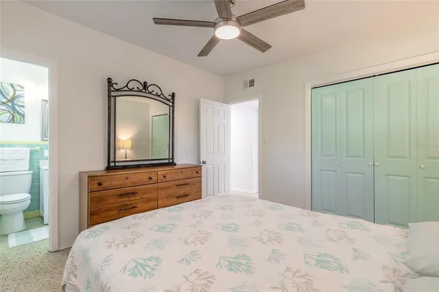 a bedroom with a bed and a mirror on the dresser