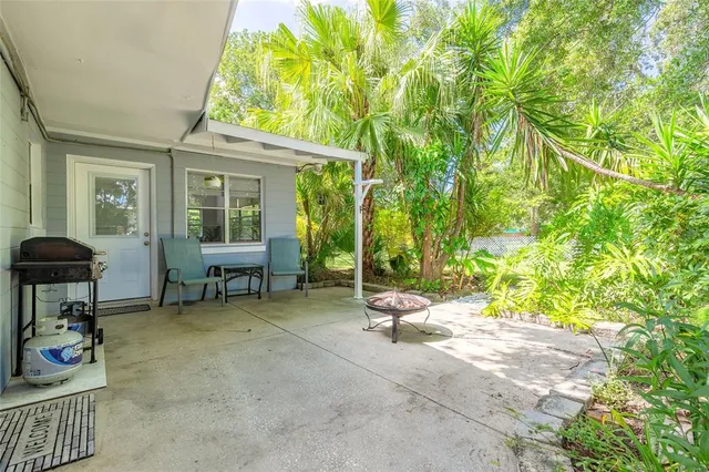 a view of patio with chairs and tables with wooden fence