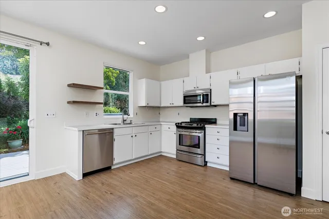 a view of a big room with wooden floor and windows