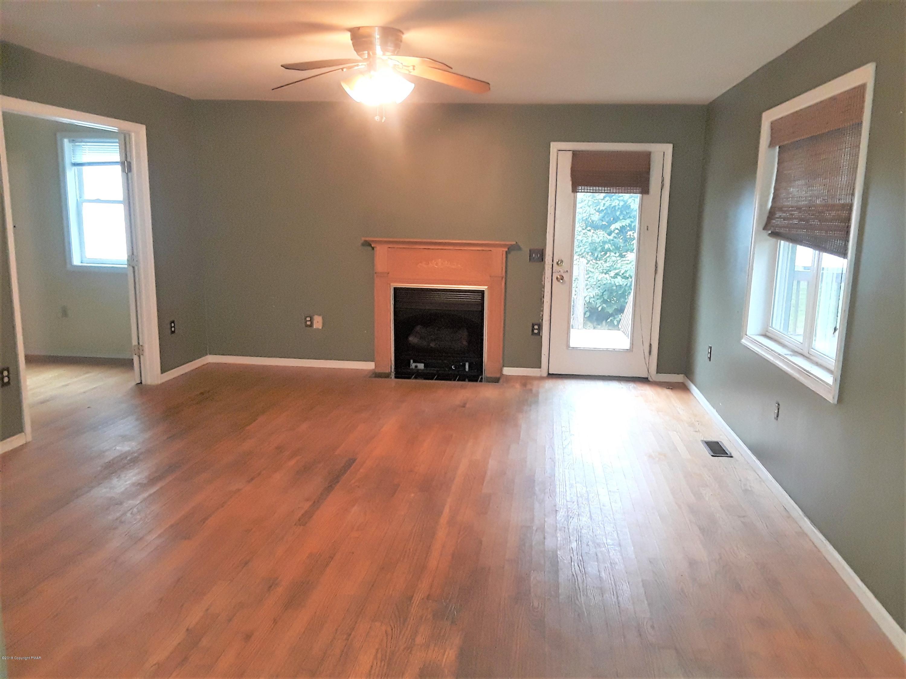 3105 Sequoia Road Tobyhanna, PA 18466 - Photo 12 of 29 an empty room with wooden floor fireplace and windows