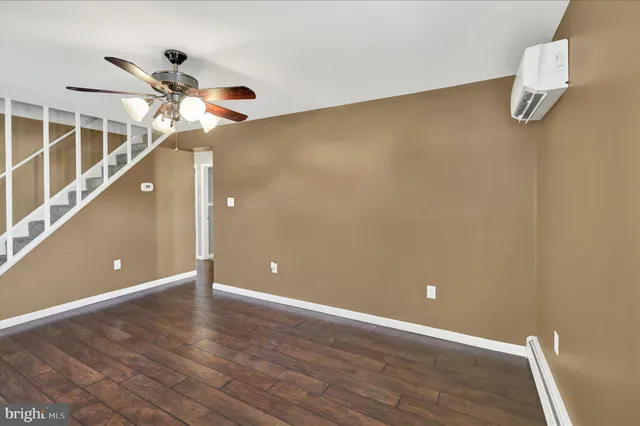 a view of a room with a ceiling fan and wooden floor