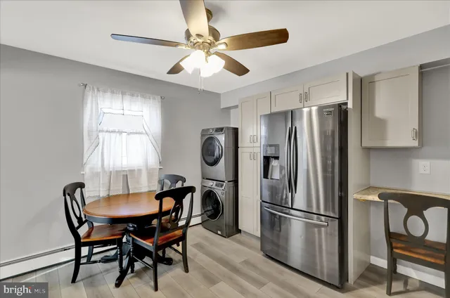 a kitchen with stainless steel appliances a refrigerator a table and chairs