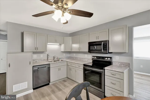 a kitchen with stainless steel appliances granite countertop a sink dishwasher a stove top oven a refrigerator with island and cabinets