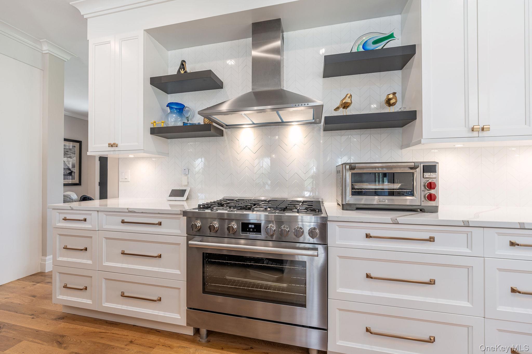 1665 Glenn Road Southold, NY 11971 - Photo 11 of 46 a kitchen with stainless steel appliances granite countertop a stove and wooden cabinets